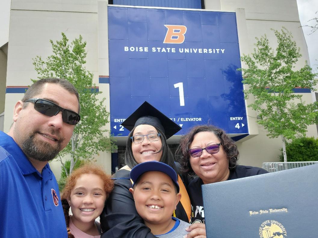 Ebony Baines and her family in front of a Boise State sign on graduation day. 