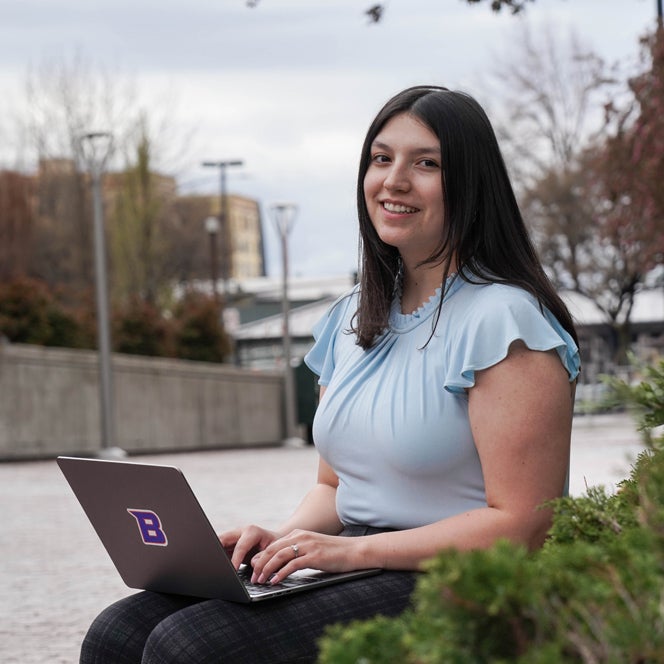 An online business degree student works on a laptop