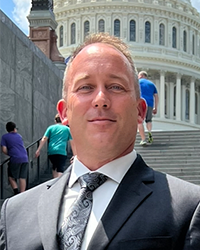 Kevin Hunter poses in front of a government building.