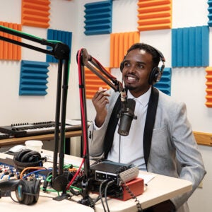 a student talking into a microphone in a recording booth