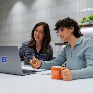 Two students work together at a laptop.