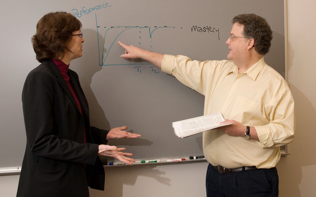 Steve Villachica and female pointing at white board
