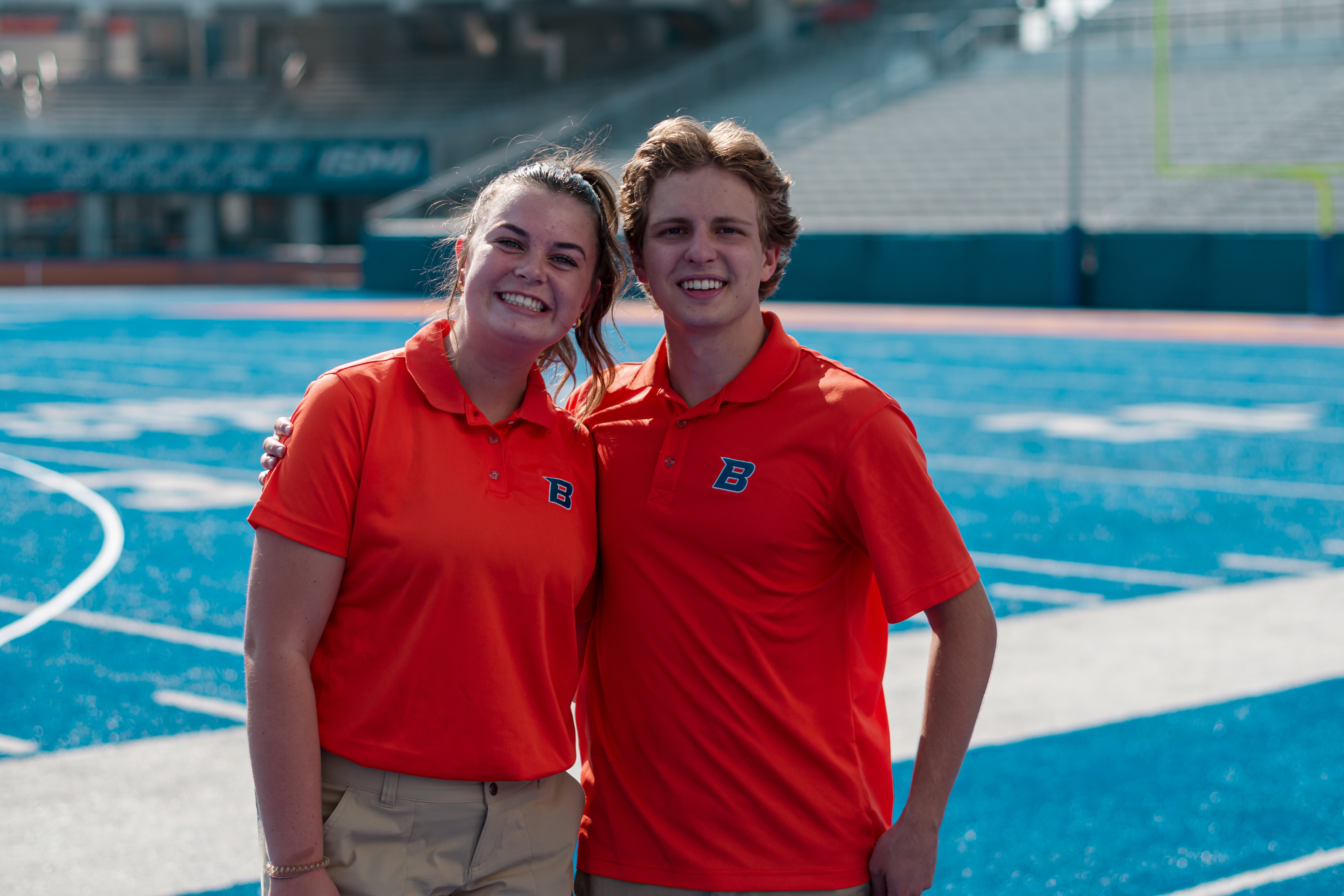 Two Boise State orientation leaders standing on the blue turf