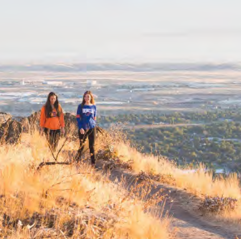 Students walking in foothills with city in background