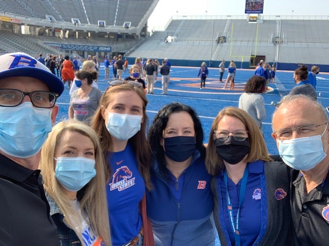 Faculty group photo on the blue turf