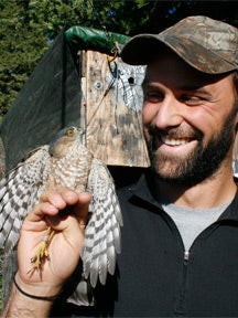 Photo of Neil Paprocki with a raptor on hand
