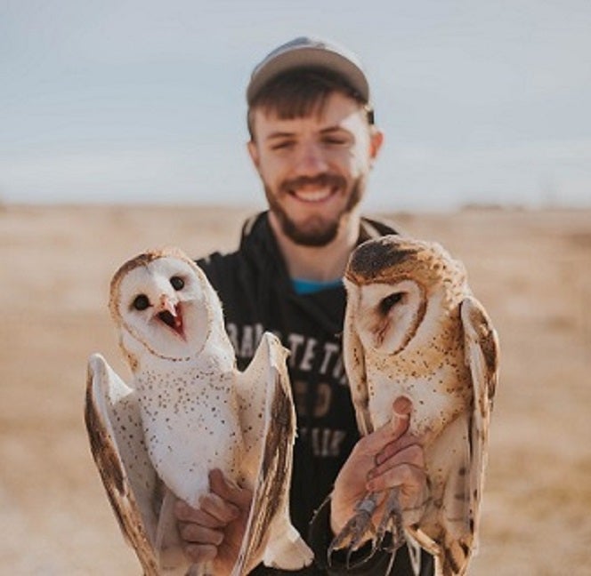 Brian Busby holding 2 barn owls