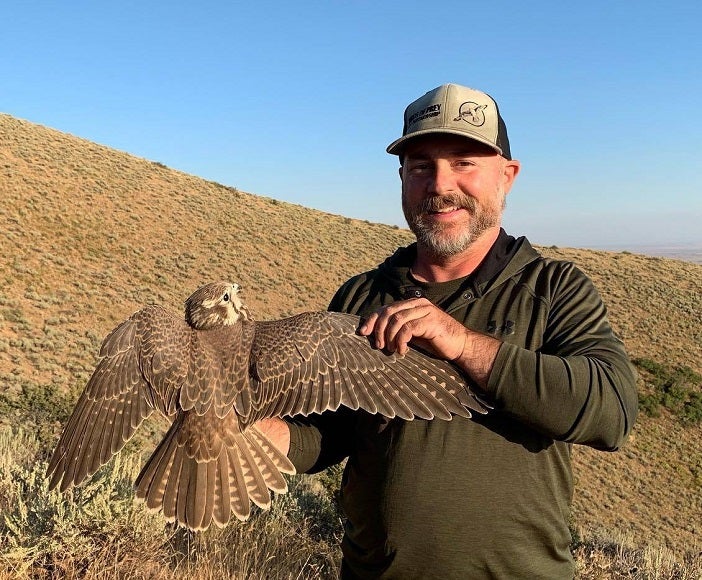 Steve Alsup holding a Prairie Falcon in the field