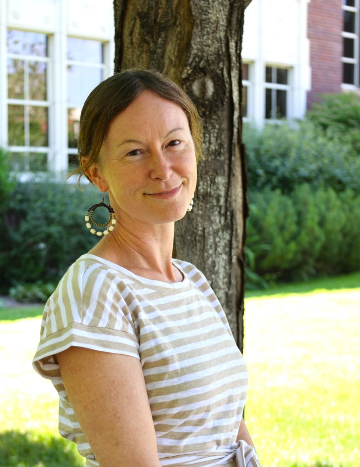 Natasha French profile picture. She stands against a tree in the sunshine.