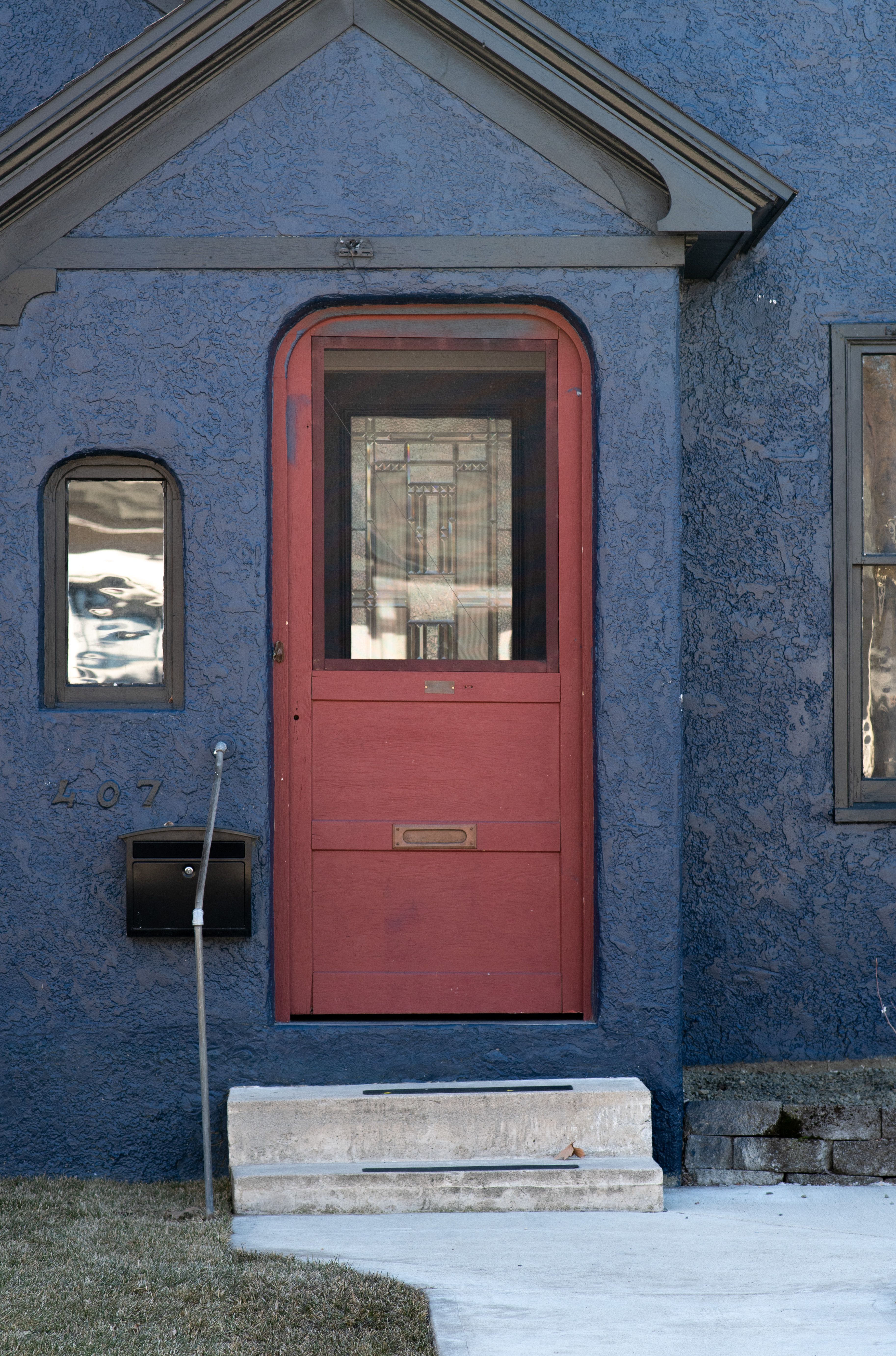 A red door on a blue house