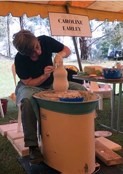 Photo of Caroline Earley turning clay on a wheel. Photo by Bridgit Willis.