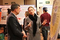 People conversing about a research presentation
