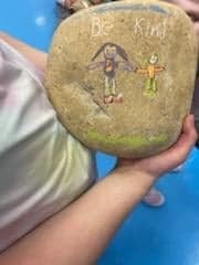 Example of a student's rock that has the words "Be Kind" and two people drawn on it. 