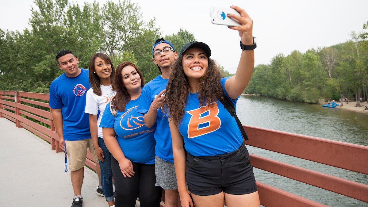 Five students take a group selfie while standing on friendship bridge