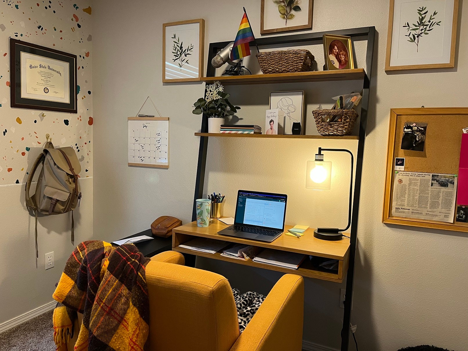 A home office with a desk, lamp, and photos on top