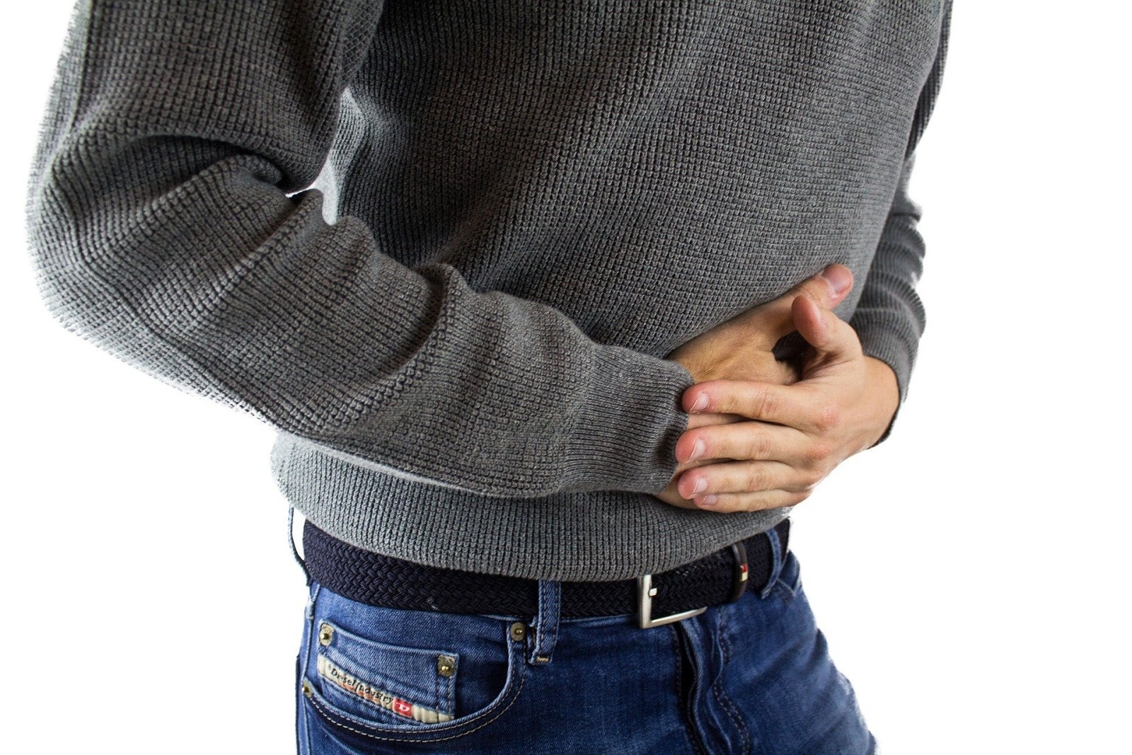 A man grips his stomach in pain. 