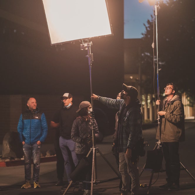 students working with lighting equipment on an outdoor set
