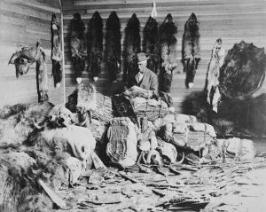 man sitting in room surrounded by furs
