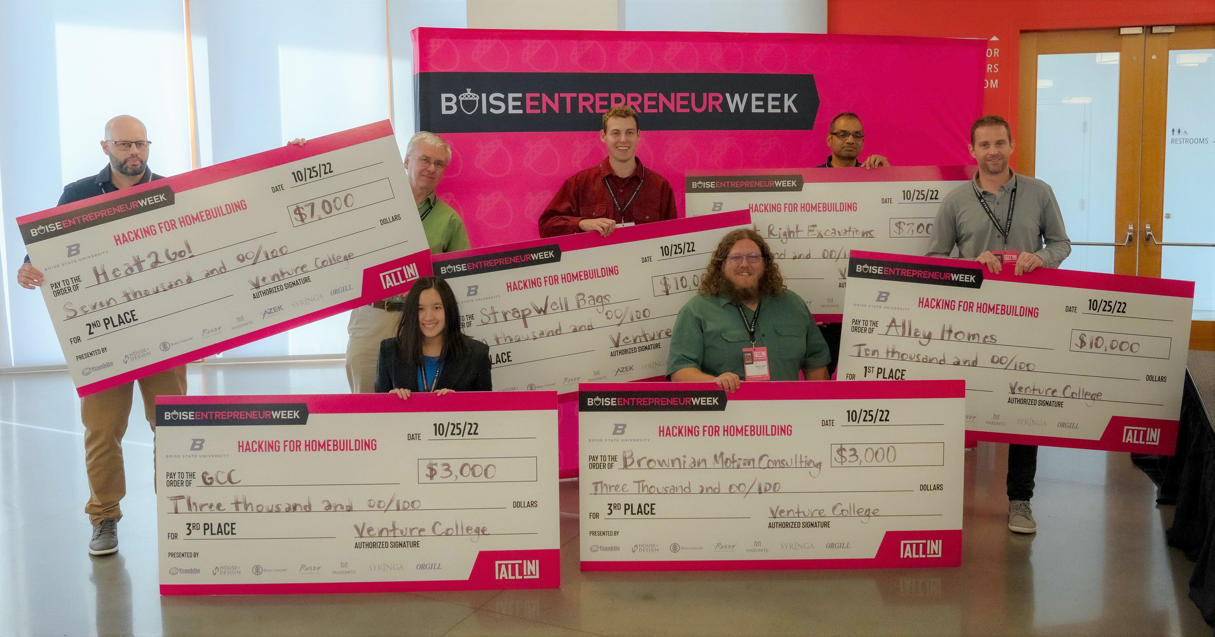 The winners of Hacking for Homebuilding hold up their checks.