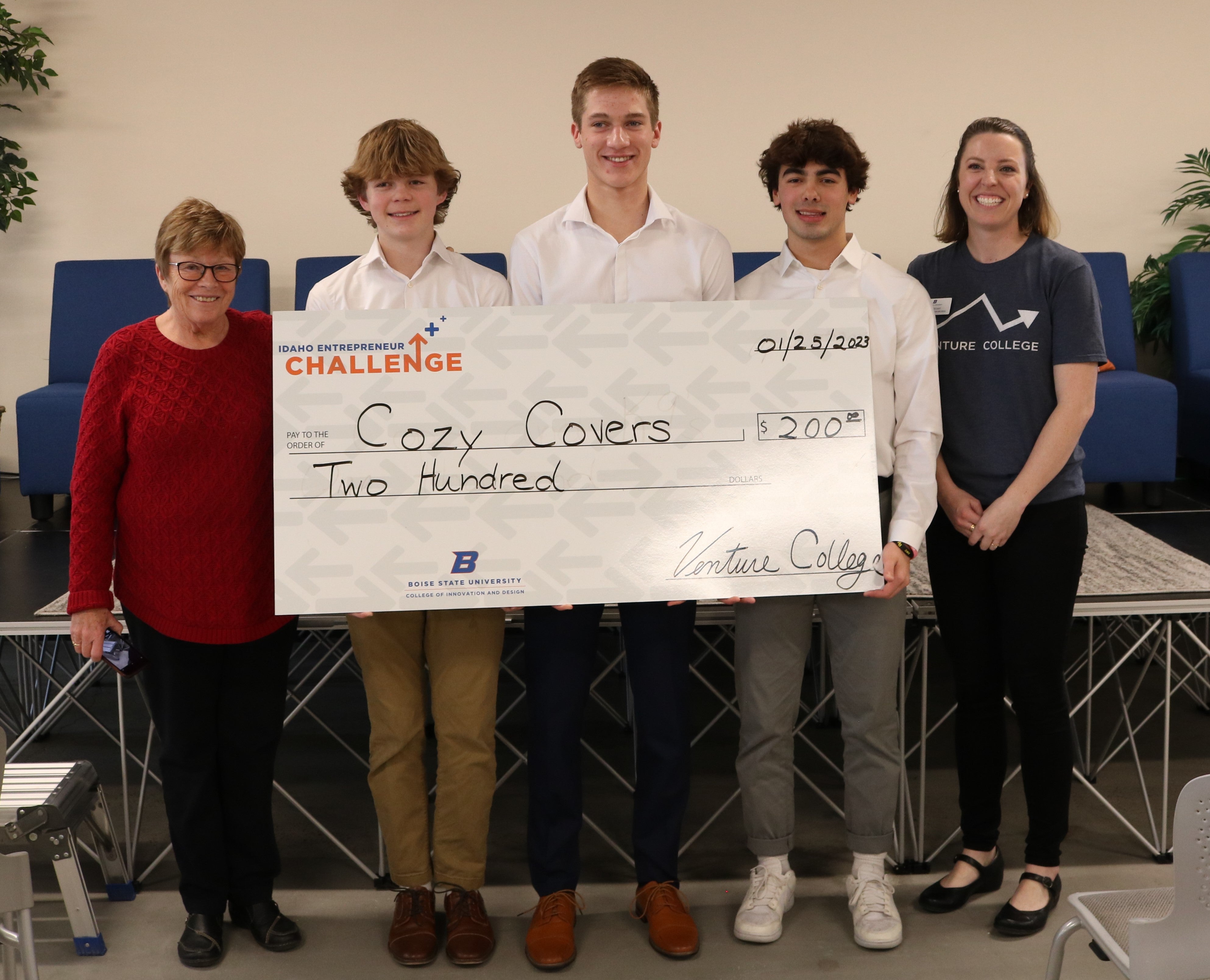 Cozy Covers team holding a big check