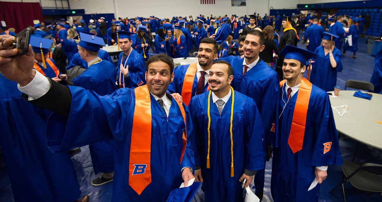 Students taking selfies at commencement ceremony