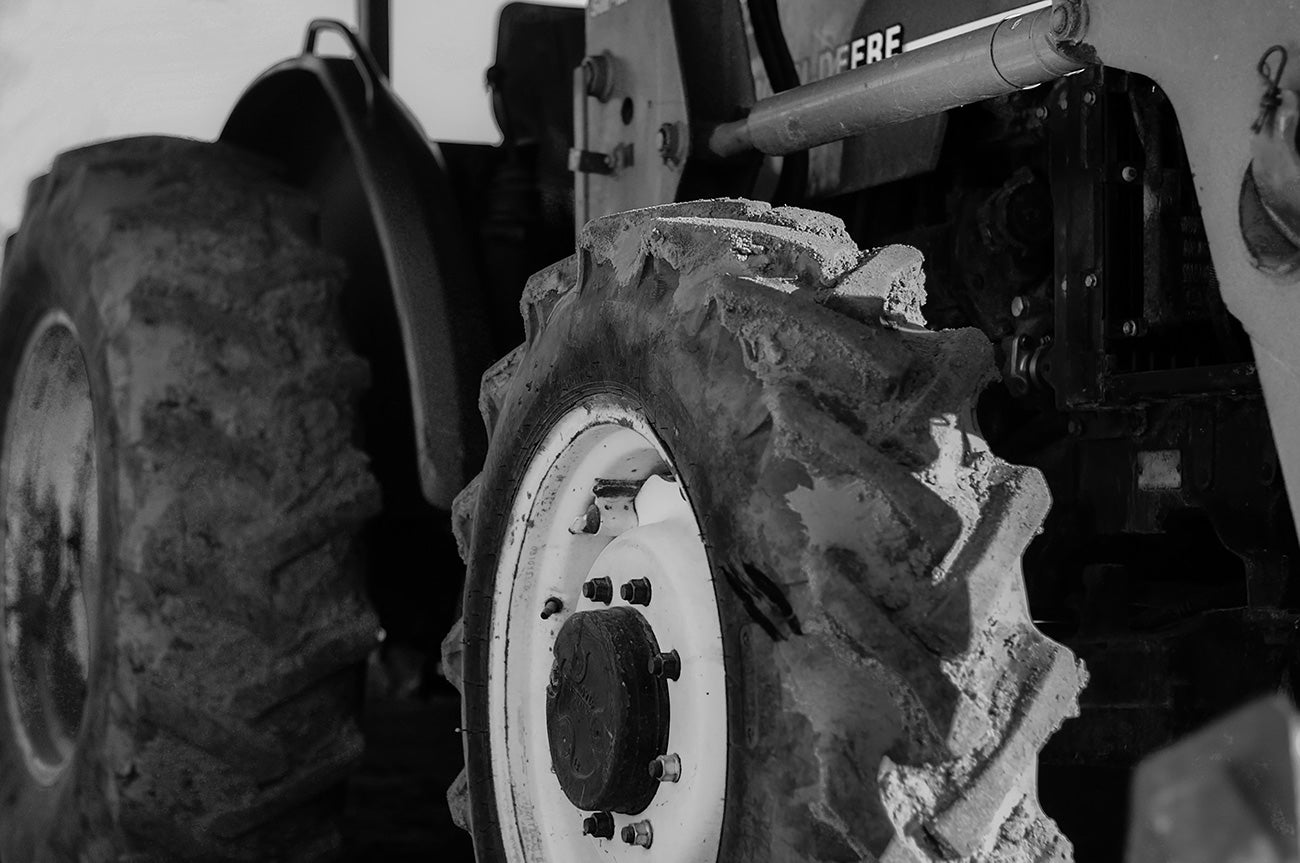 Black and white photo of a tractors muddy tires