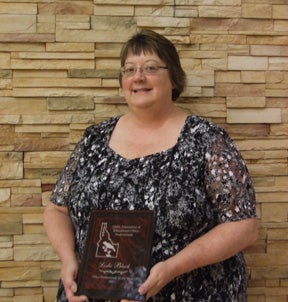 Leslie Black holds her Office Professional of the Year plaque.