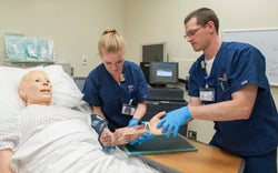 Radiologic Sciences students practice positioning an arm during a simulation.