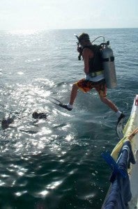 Scuba diver jumping into ocean off boat
