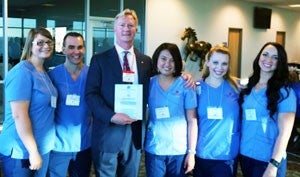 Rodney Reider, president and CEO of Saint Alphonsus, stands with Boise State nursing students.