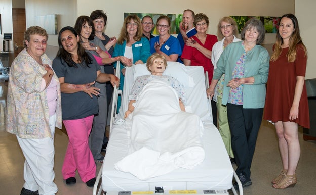 Group photo of the first simulation cohort with simulation dummy and make-up wounds.