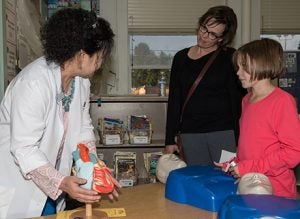 Picture of a Garfield elementary student learning about the heart with a School of Nursing faculty.