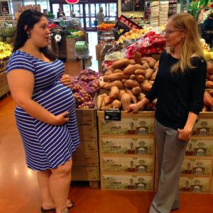 Cynthia Curl, right, speaks with a pregnant Boise State alumna in the produce section.