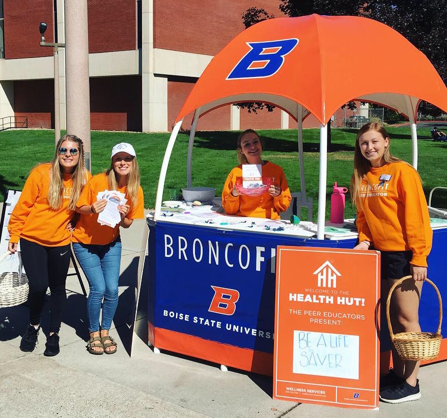 Peer Educators handing out goodies at their tent on the Boise State Quad