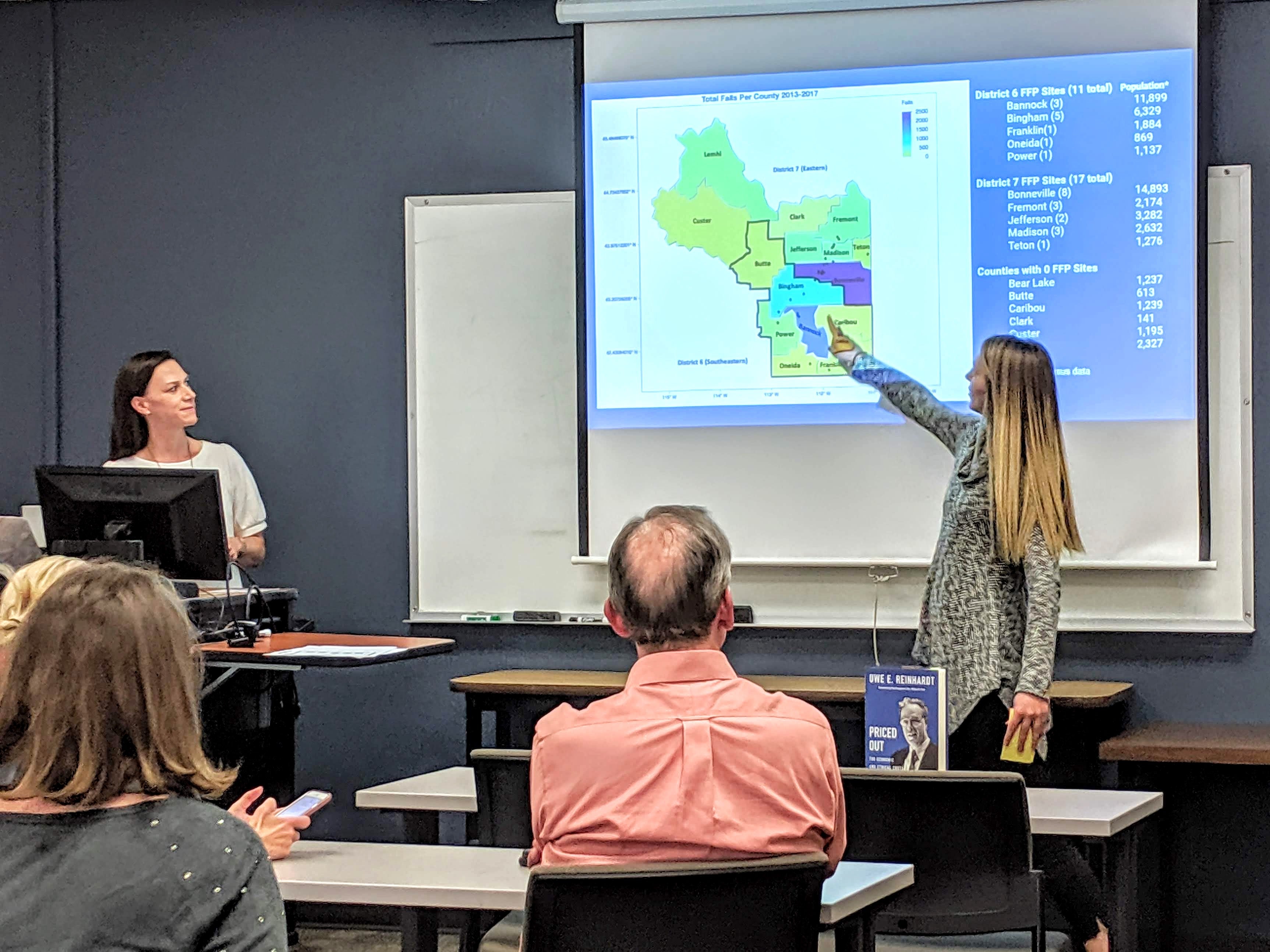 Students Elizabeth Ryder (left) and Brooke Rude (right) present their findings on Health Districts 6 and 7.