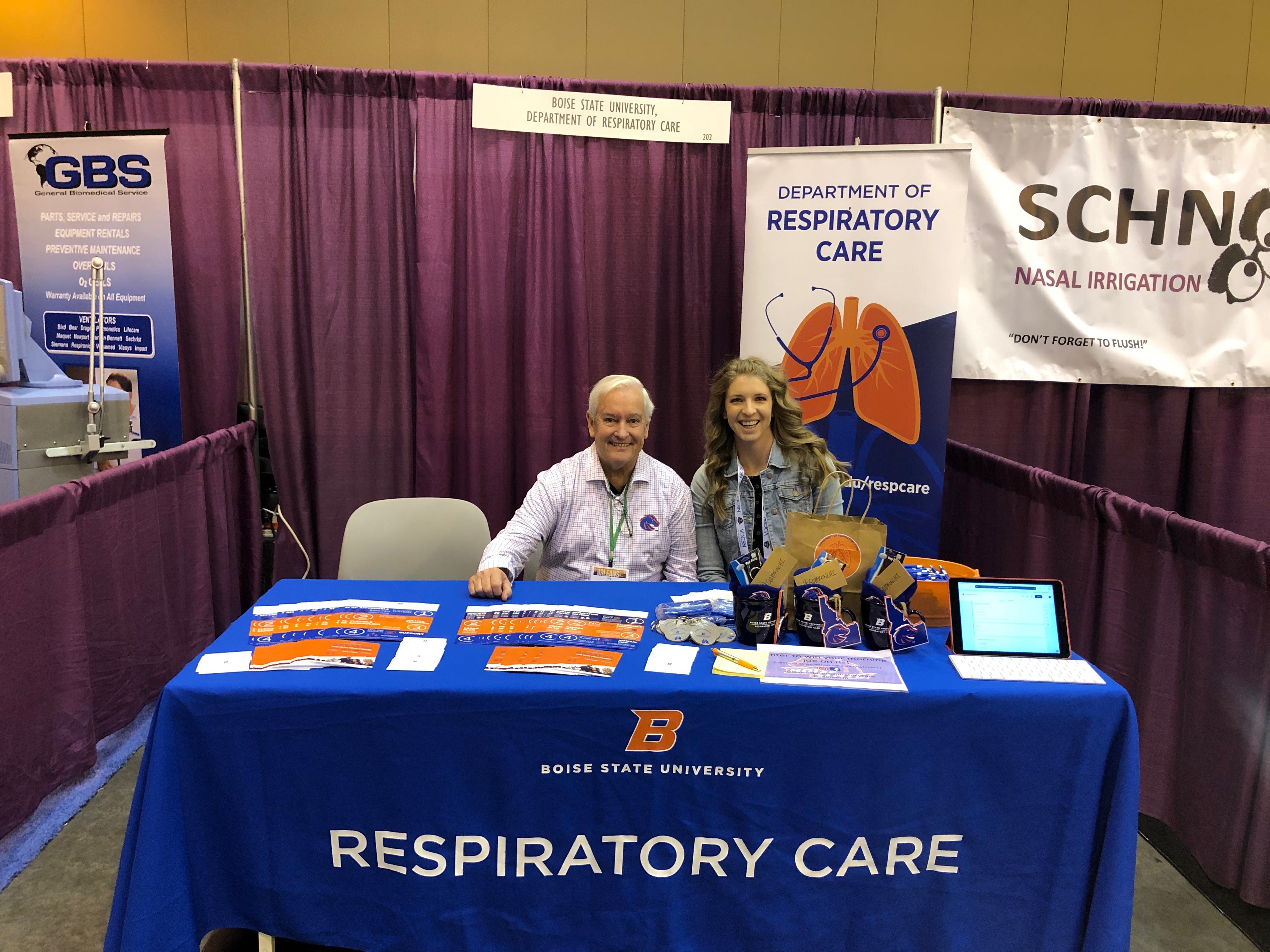 Faculty sitting at a table at the event that reads "Respiratory Care" 
