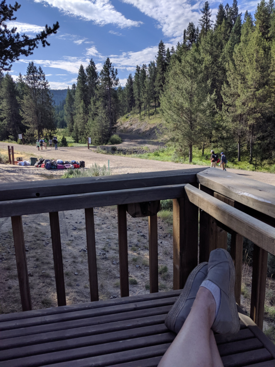 Campers walk on a trail visible from a porch.