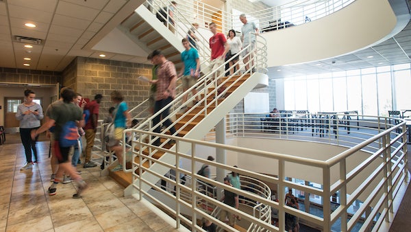 Students walking in a hall and on a staircase