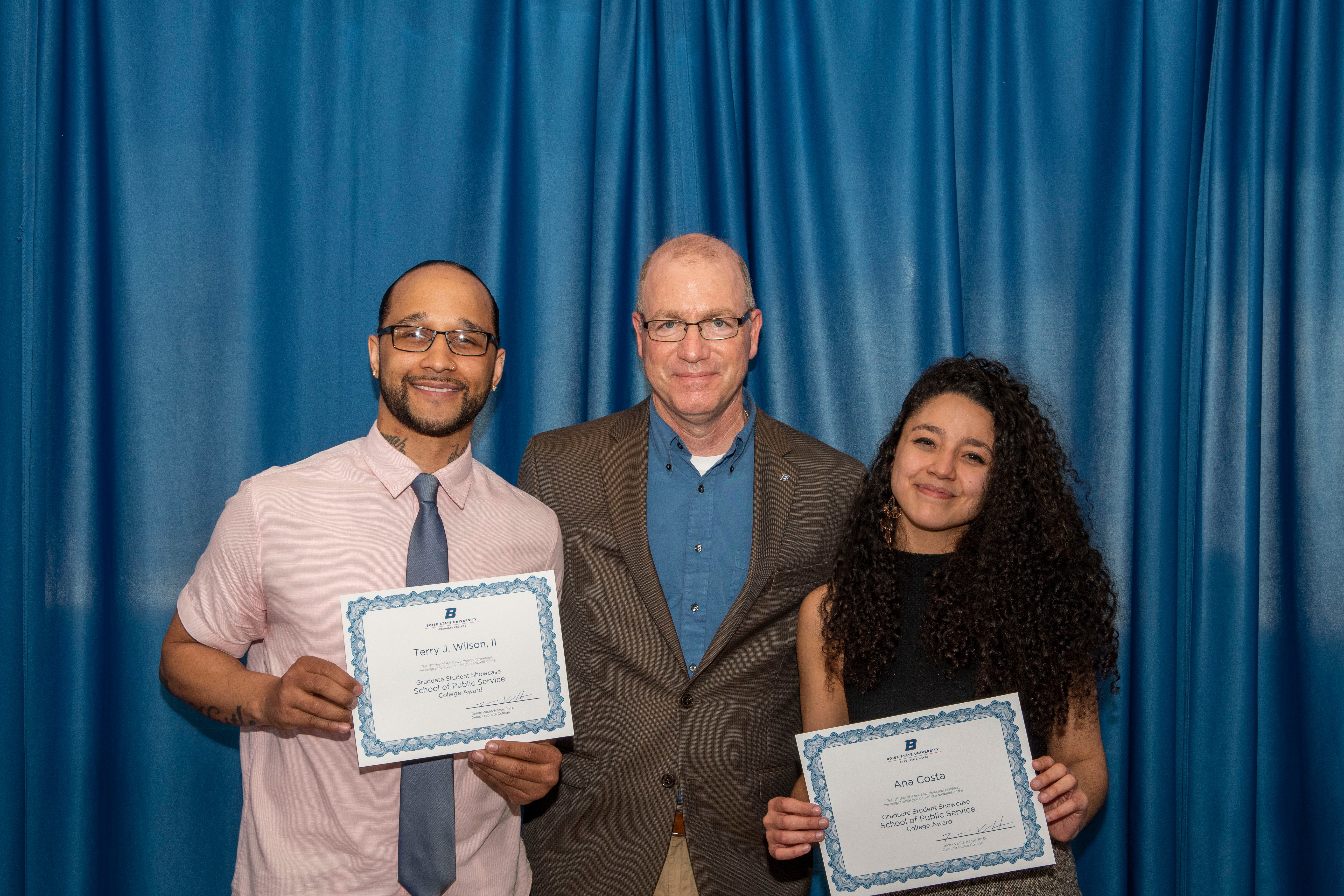Two of 70 award winners, Terry Wilson II (left), and Ana Costa (right) pose with School of Public Service Associate Dean Andrew Giacomazzi (center)
