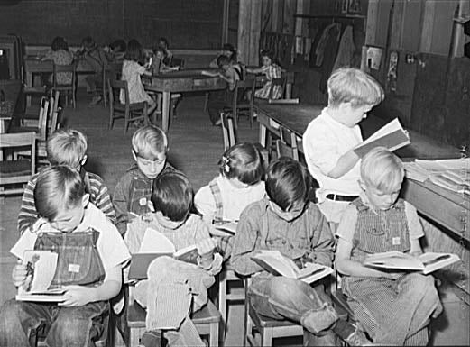 Children in school at the Farm Security Administration farm workers’ camp - see caption for full description