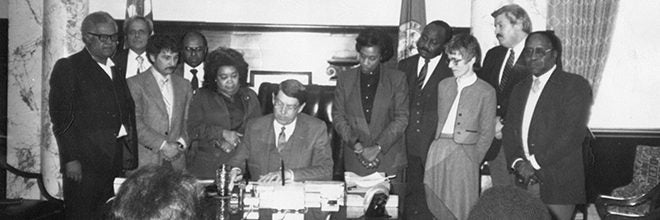 historical photo of Marilyn Shuler with Governor Evans signing a bill