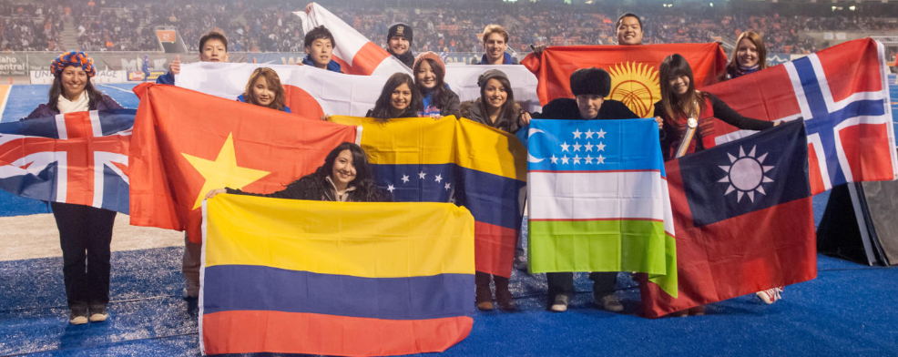 International students proudly displaying their country's flags on the blue turf