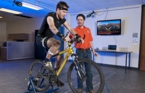 Researcher working with subject, tracking movements on a bike