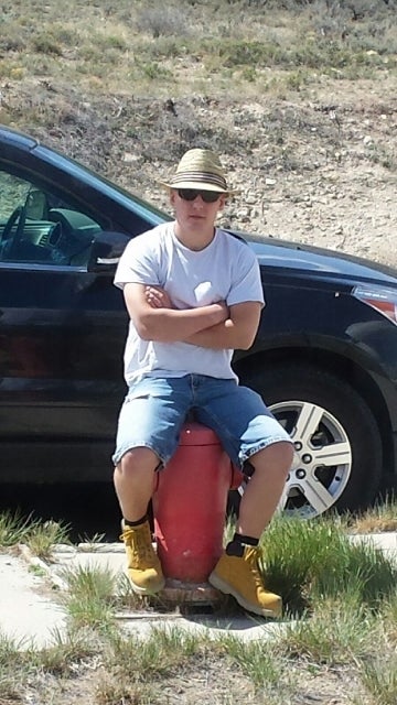 Author sitting on water hydrant in the Desert