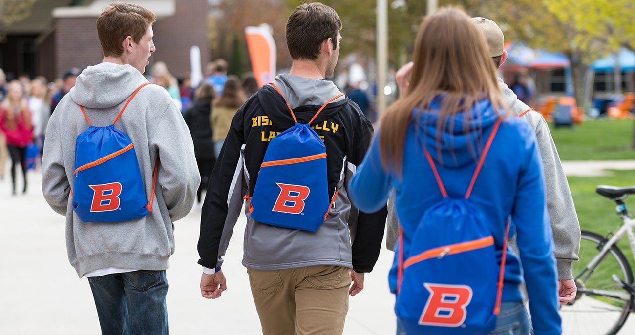 Students walking down path with Boise State backpacks
