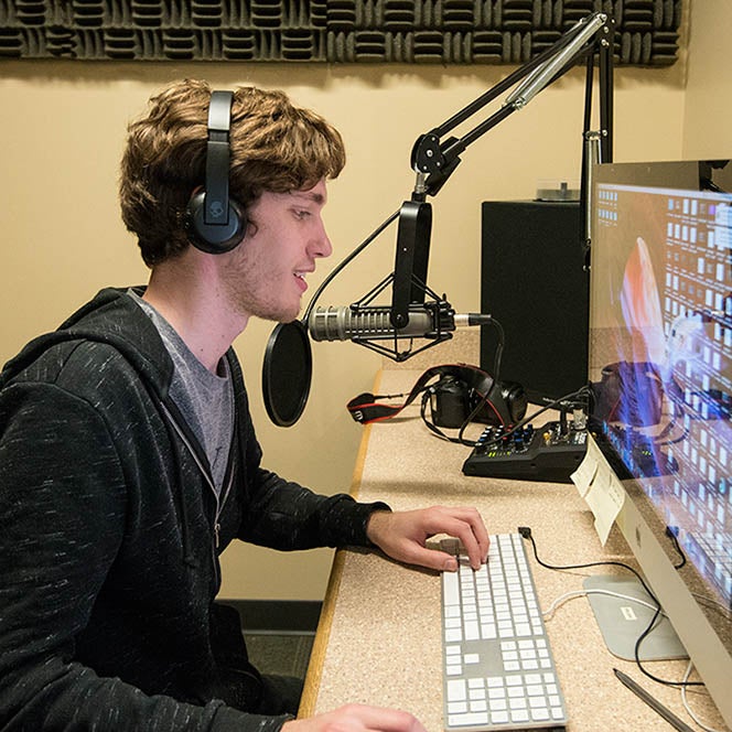 Student working on computer and recording equipment