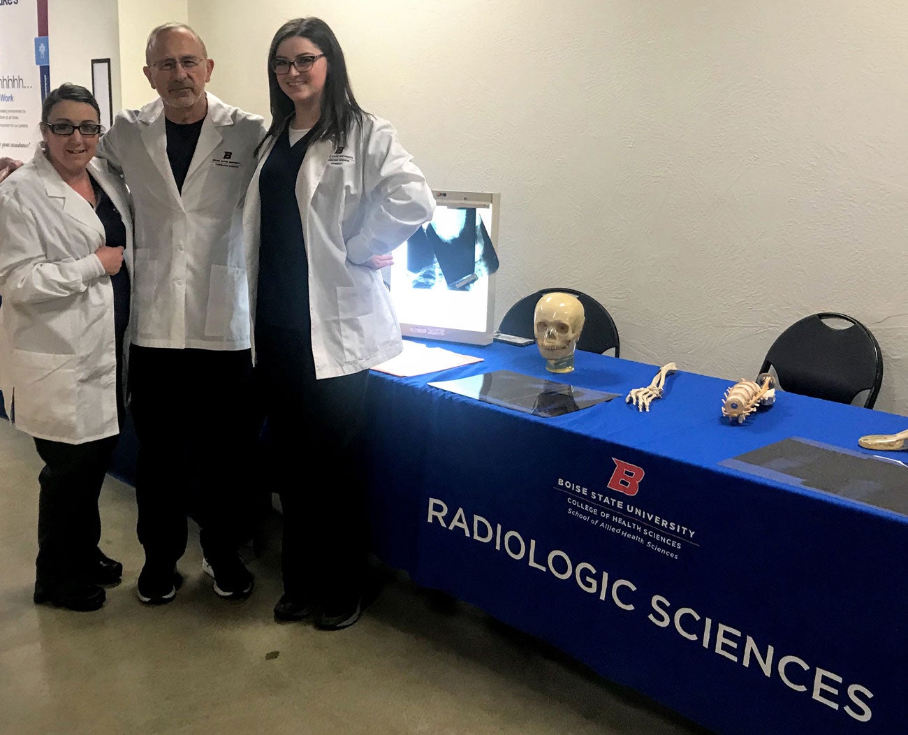 Rad Sci members standing in front of Rad Sci Table at the event