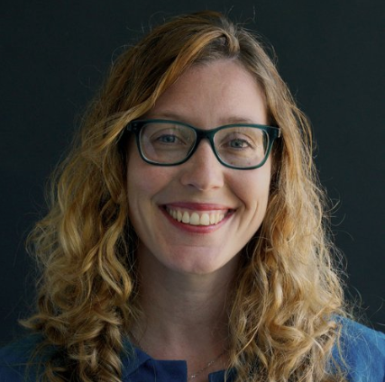 Smiling portrait of Amanda. She wears glasses.