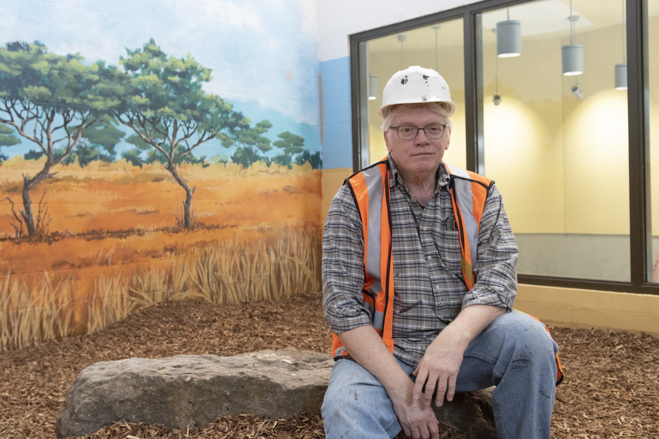 A man poses in a future animal cage in Zoo Boise