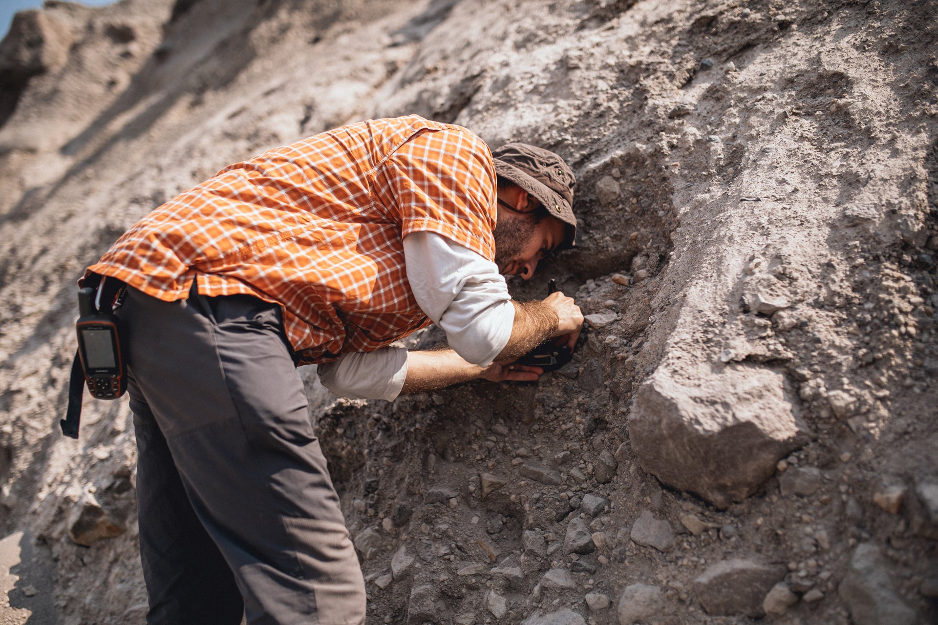 Photo of Italian research student scraping deposits with small hand tool